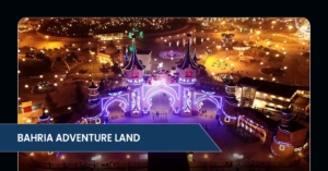 Aerial view of Bahria Adventure Land at night, showcasing illuminated castles, vibrant lights, and festive activities in a theme park setting.