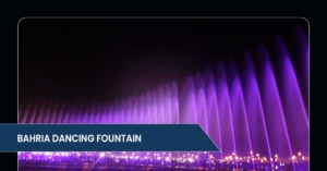 Colorful streams of water dance in the air at the Bahria Dancing Fountain, illuminated with vibrant purple lighting at night.