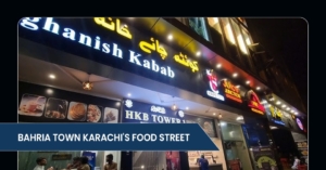 Brightly lit food street in Bahria Town Karachi, showcasing various eateries including Afghanish Kabab and HKB Tower.