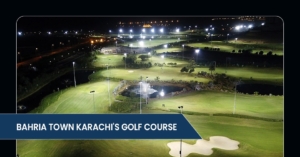 Aerial view of Bahria Town Karachi's illuminated golf course at night, showcasing lush greens, water features, and surrounding lights.